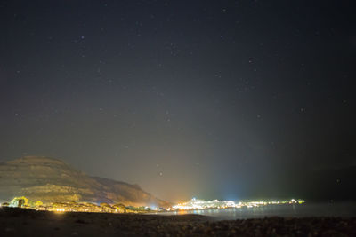 Illuminated city against sky at night