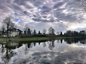 Calm lake against cloudy sky