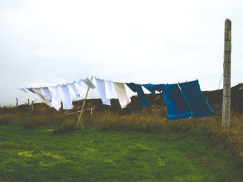 Clothes drying on field against sky