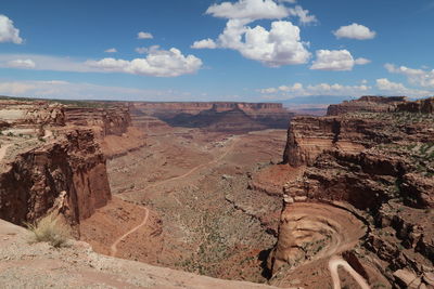 Rock formations on landscape against cloudy sky