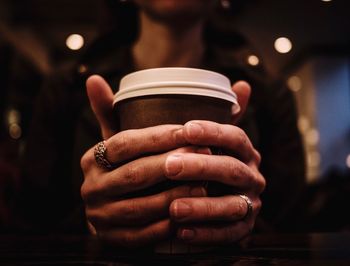 Close-up of hand holding coffee cup