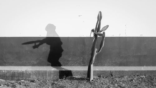 Man with umbrella against clear sky