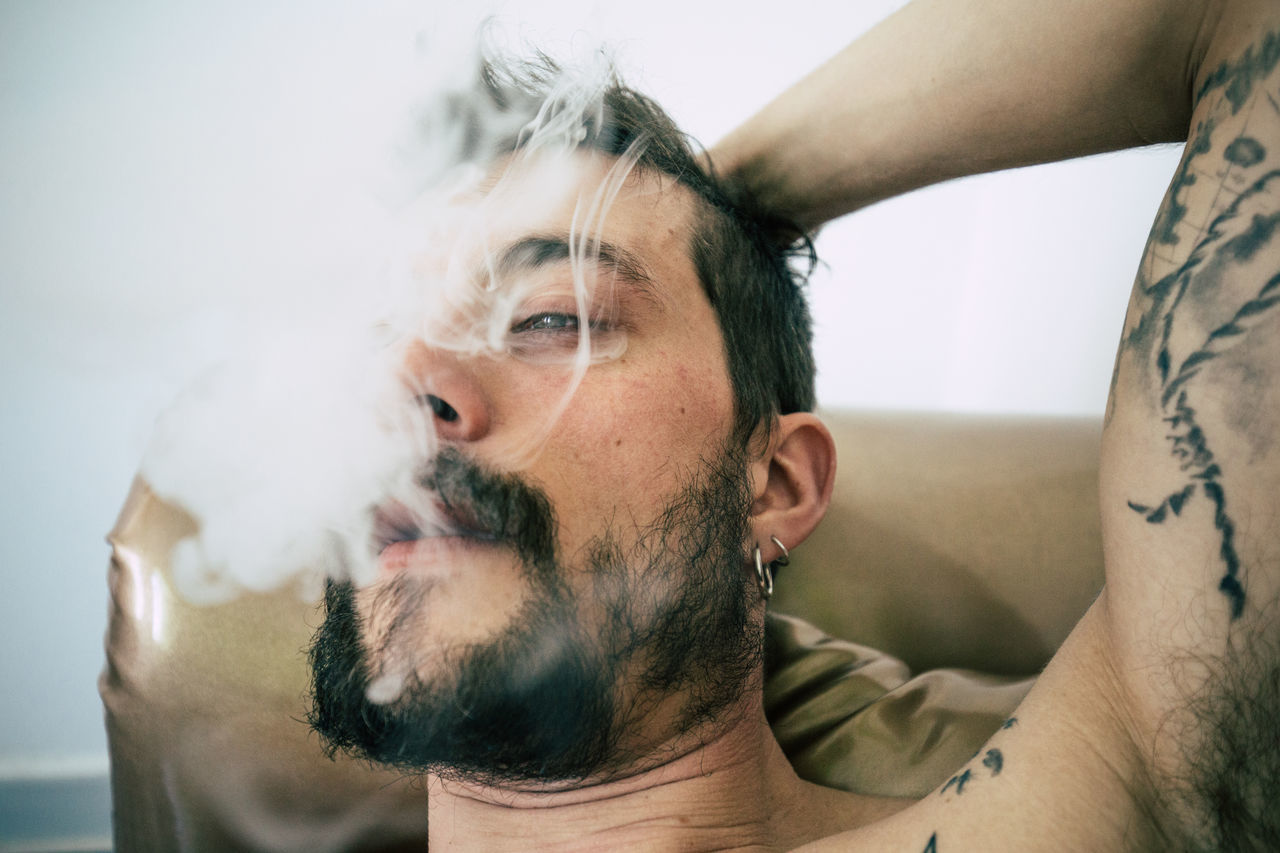 Close-up of tattooed man smoking