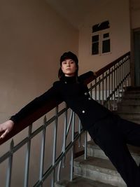 Portrait of young woman standing on staircase