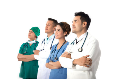 Smiling doctors standing against white background