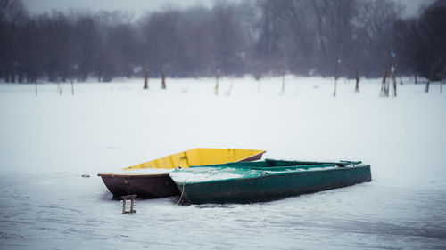 Boat moored on shore during winter