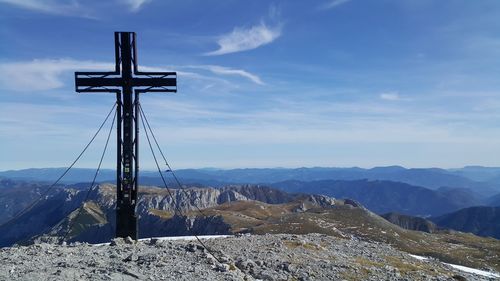Cross on mountain against sky