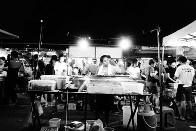 People at illuminated market at night