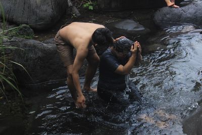 High angle view of people on rock by river