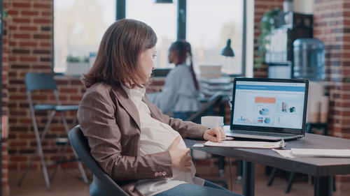 Pregnant employee working at office