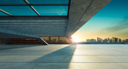 Modern buildings in city against sky during sunset