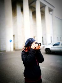 Woman photographing in city