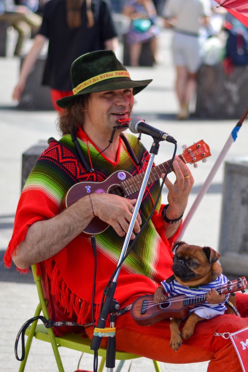 real people, men, domestic animals, domestic, pets, incidental people, one animal, clothing, vertebrate, mammal, focus on foreground, people, holding, canine, dog, hat, day, pet owner