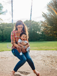 Full length of mother and girl on playground