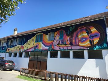 Low angle view of graffiti on building against clear sky