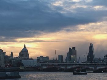 City at waterfront against sky during sunset