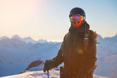 Portrait of a skier on the mountain at sunset. portrait of a woman in a ski resort against the