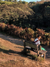 Backpacker sitting on bench against mountain