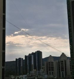 Low angle view of buildings against cloudy sky