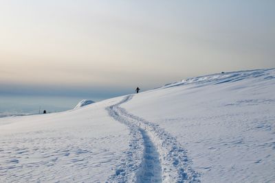 People skiing on snow covered landscape