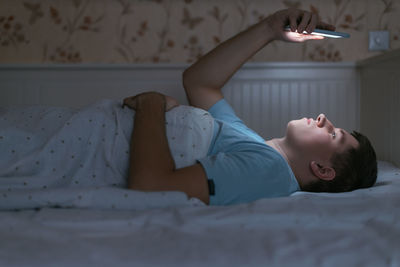 Man suffer from sleep disturbance and use smartphone at night. young male addict from phone. 