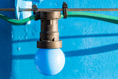 Close-up of light bulb hanging on cable