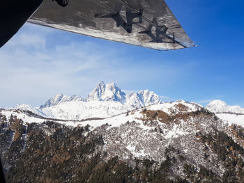 Low angle view of snowcapped mountains against sky