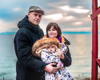 Portrait of family with baby in arms against baikal lake