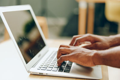 Midsection of woman using laptop on table