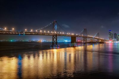 Low angle view of bay bridge over san francisco bay at night