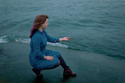 Side view of woman sitting in sea