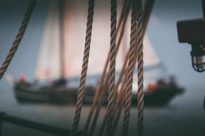 Close-up of rope tied to moored in sea