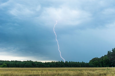 Scenic view of lightning over field against sky