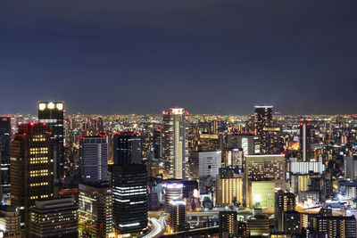 Illuminated cityscape against sky at night