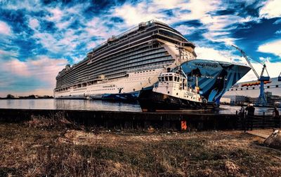 Abandoned boat moored on shore against sky