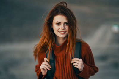 Portrait of smiling young woman standing outdoors