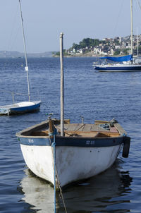 Sailboats moored on sea against sky