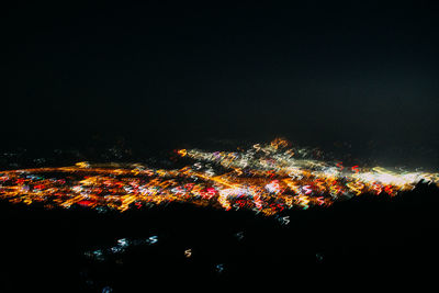 Illuminated city against sky at night