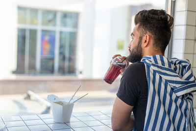 Mid adult man drinking glass at home