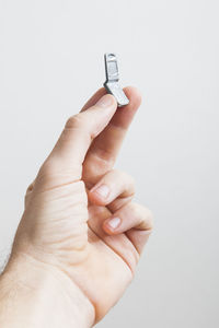 Close-up of hand holding hands over white background
