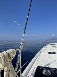 Cropped boat sailing on sea against blue sky