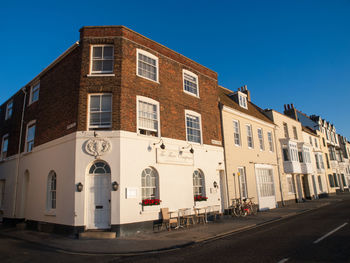 Street by building against blue sky