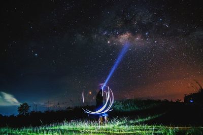 Light painting on field against sky at night