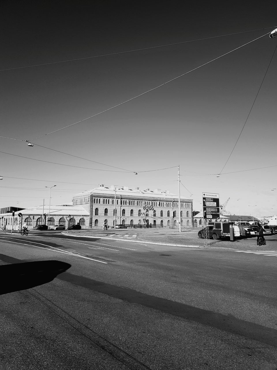 CARS ON ROAD BY BUILDINGS AGAINST SKY