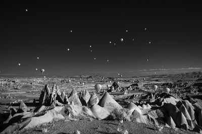 Hot air balloons flying over cappadocia against sky