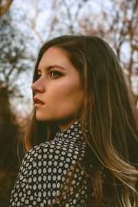 Beautiful young woman looking away in forest