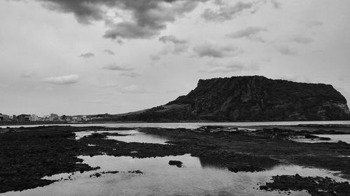 Rock formations by sea against sky