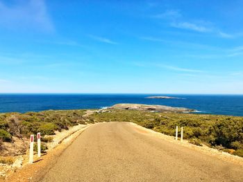 Rear view of road by sea against sky