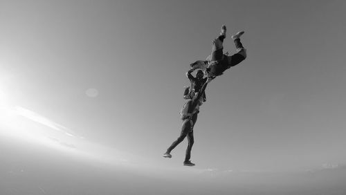 Sunset skydiving. 3-way skydive hybrid formation. aerial view low angle view free-fall man jumping. 