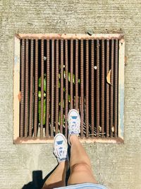 Directly above low section of woman standing on drain